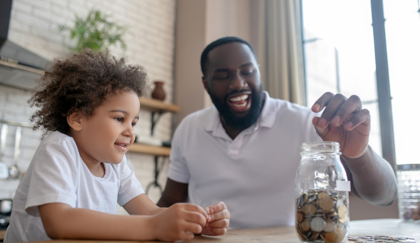 man and son placing money in a jar