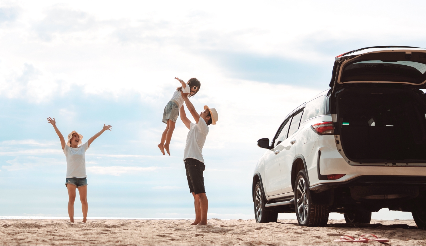 Family on a beach with new car
