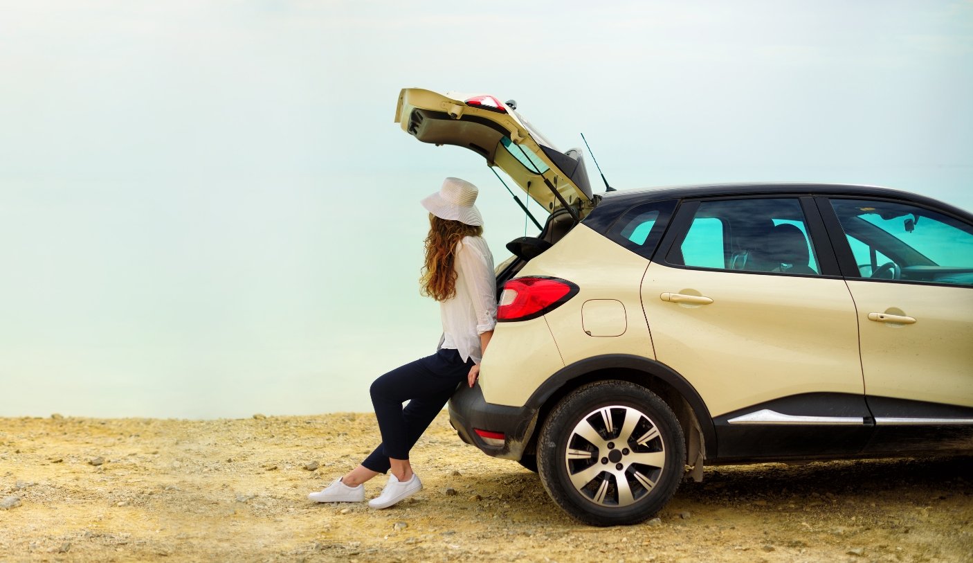 woman in back of car on beach