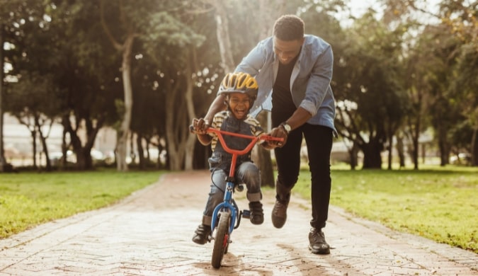 father helping son ride bike