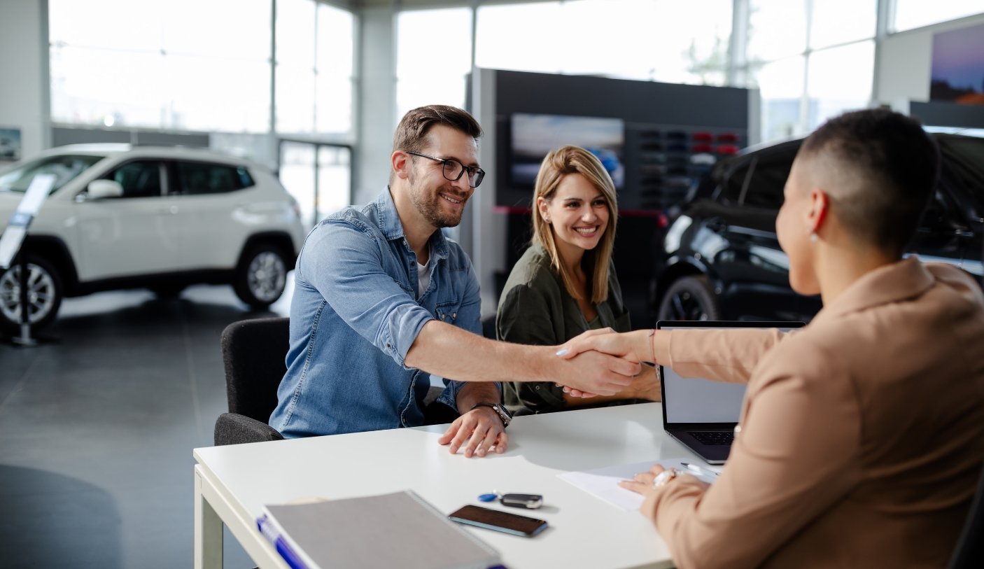 man and woman shaking had of dealer