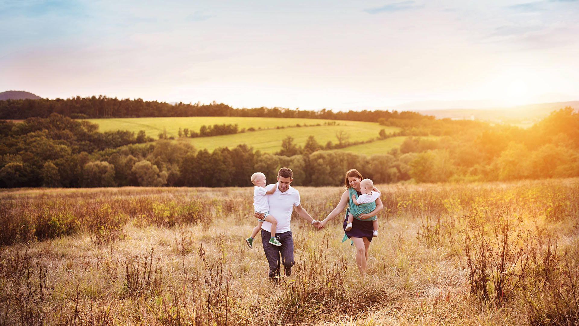 Young family walking through field