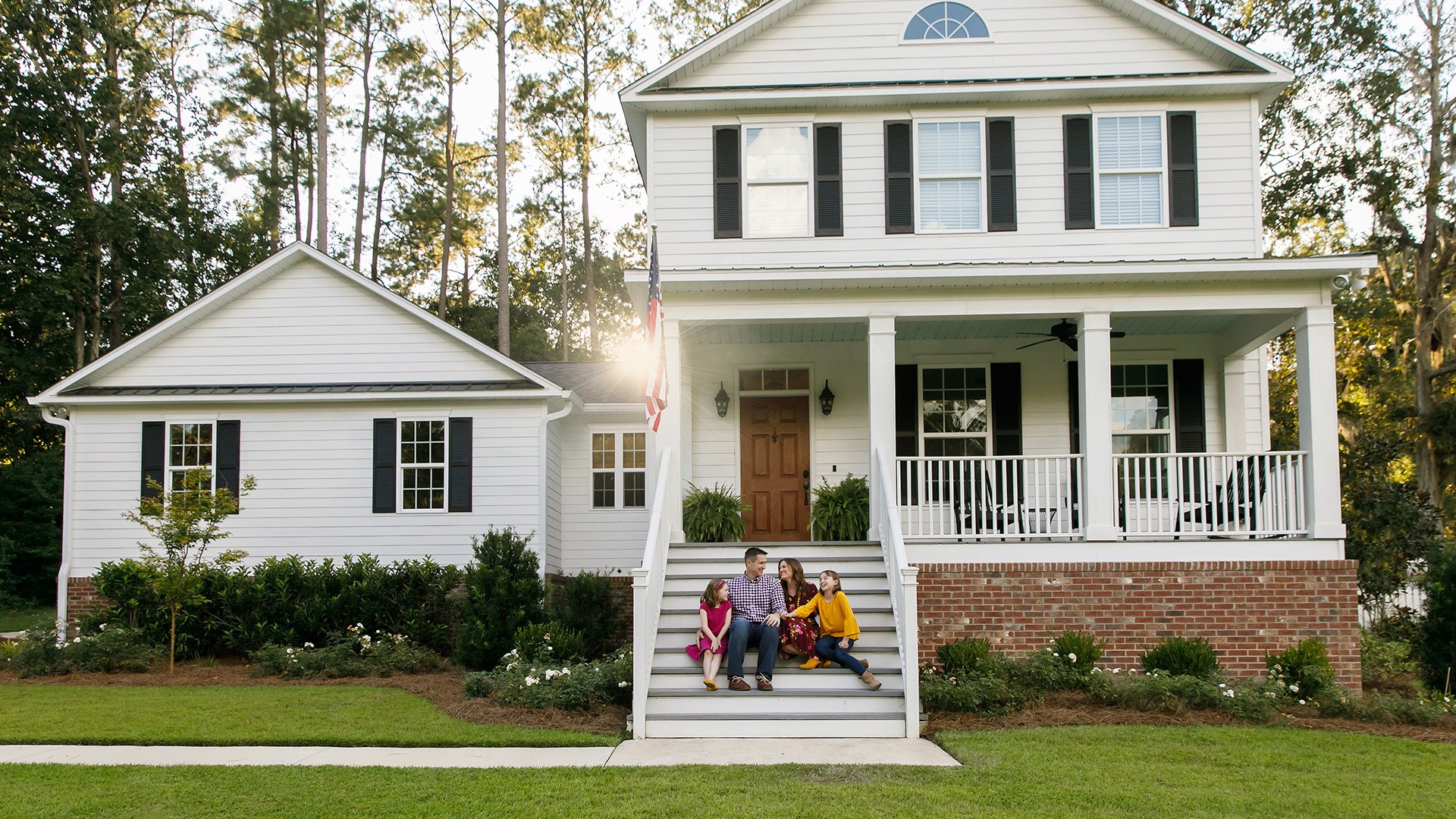 family sitting on steps of house
