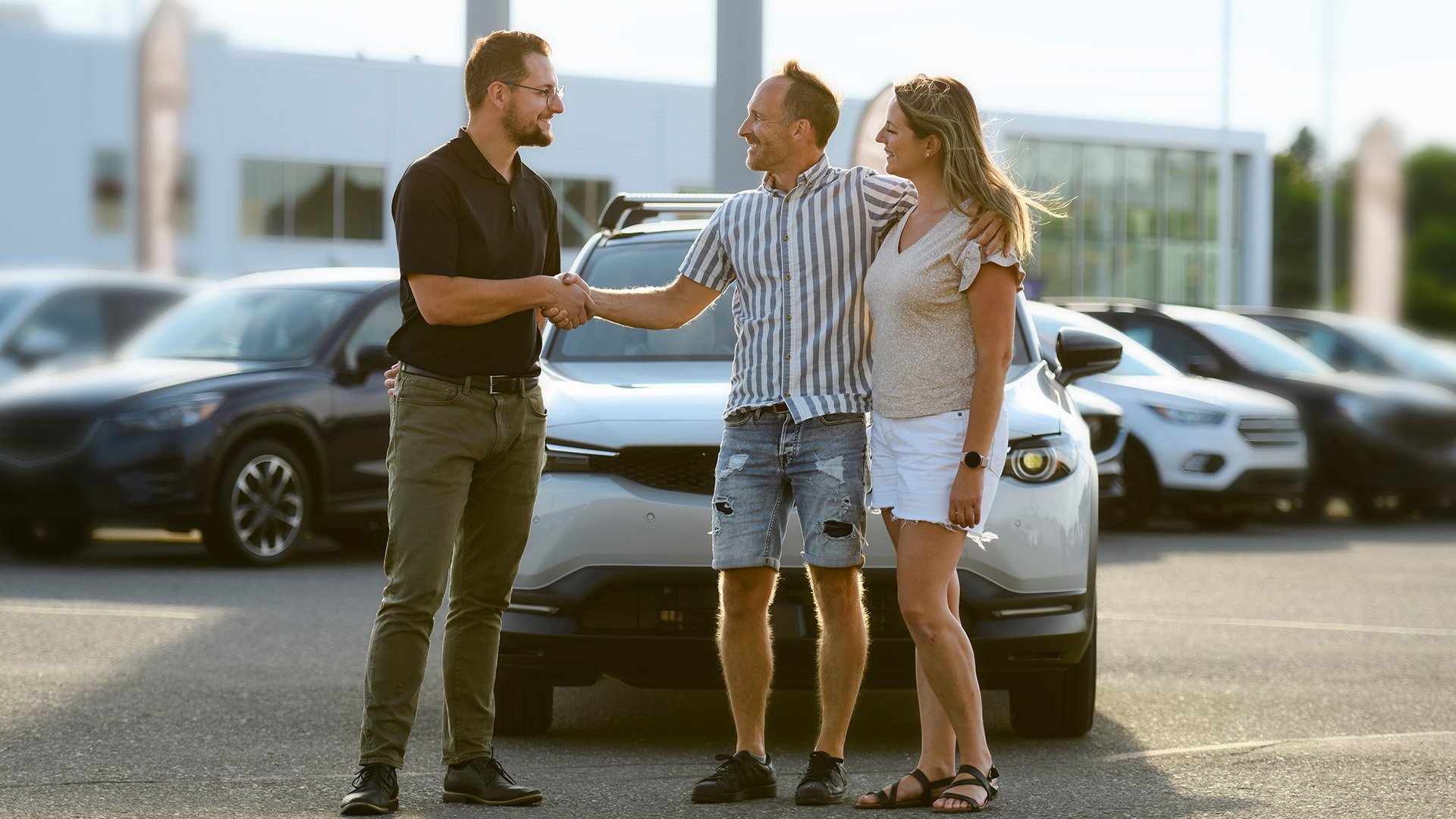 A couple shaking hands with an auto dealer