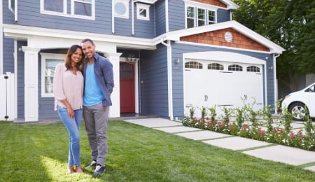 young couple in front of house