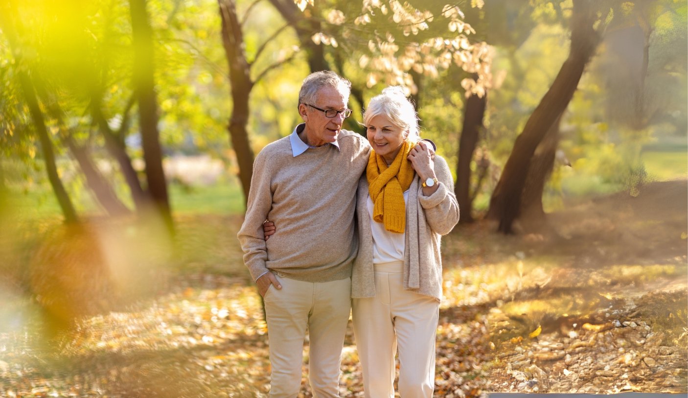 retired couple walking through park